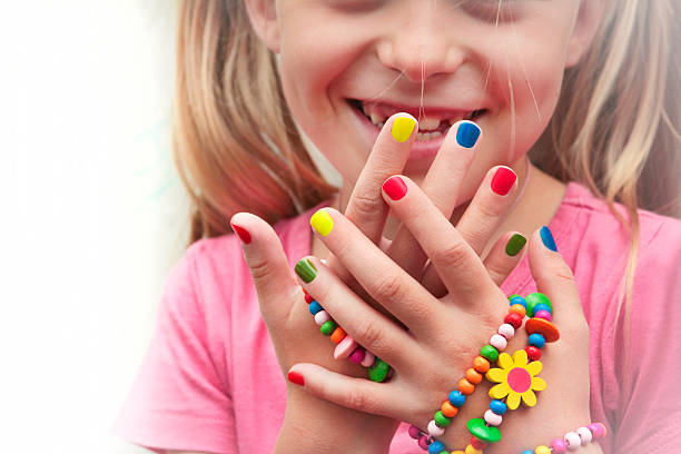Children's multicolored manicure with ornaments on a hand.